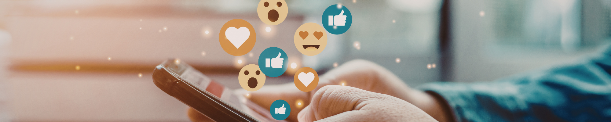 zwei Hände halten ein Handy, darüber lauter Social Media Icons wie Smileys, Herzchen, Daumen hoch und runter
