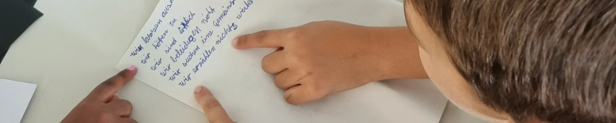 Kinderhand deutet auf einen Text