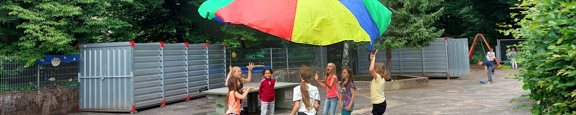 Kindr spielen mit einem Regenbogentuch - Unsere Startchancen-Programm Empfehlungen