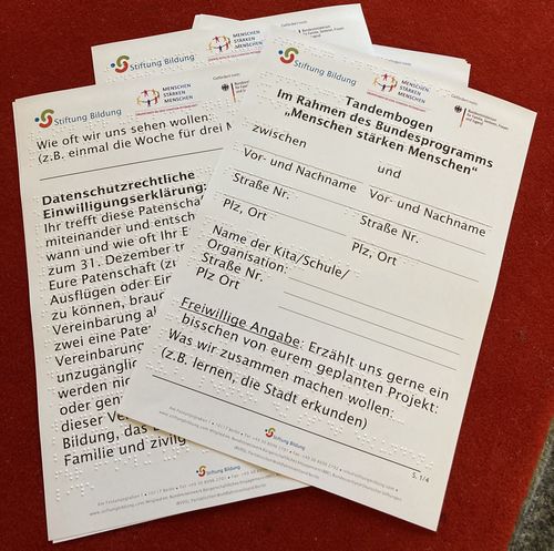 Braille-Bögen liegen auf einem Tisch - Die Tandembögen zur Anmeldung für das Patenschaftsprogramm erhalten Sie auf Anfrage 