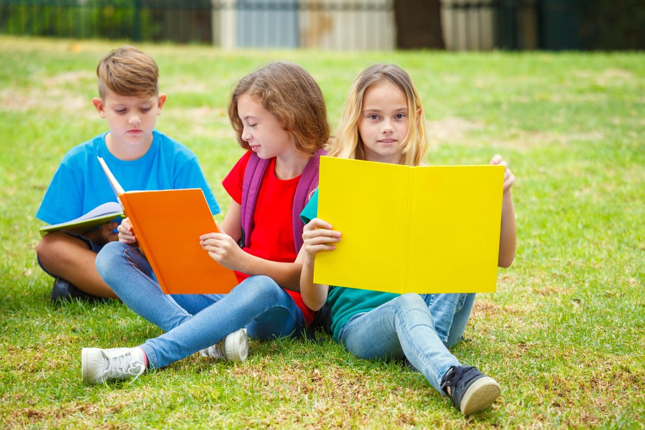 Kinder lesen im Park