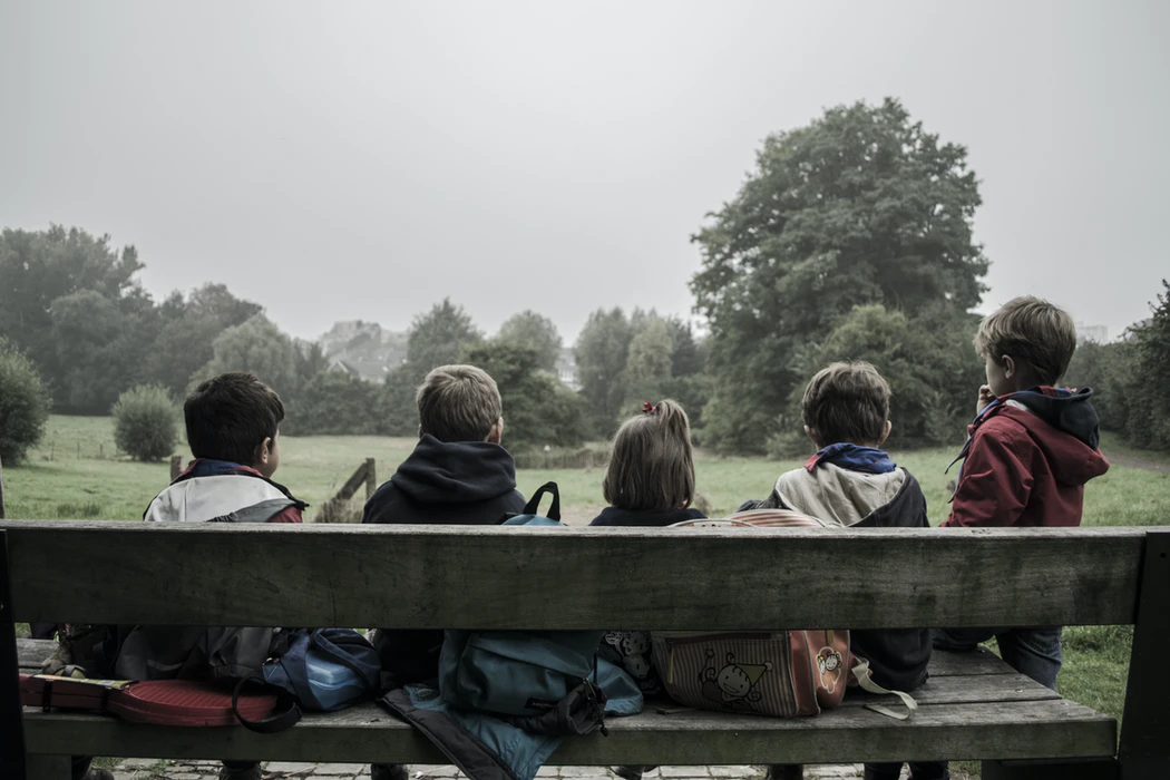 Kinder sitzen auf einer BAnk